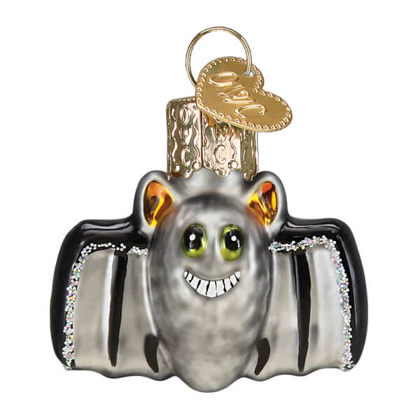 Silver glass mini bat ornament with black wing edges, glittery trim, green eyes, and a smiling face for christmas decor