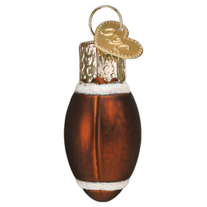 A glossy amber glass mini football ornament with white glittery stripes and a gold heart shaped tag perfect for world christmas ornaments