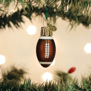 Brown glass mini football ornament with white laces and gold trim hanging from world christmas ornament tree
