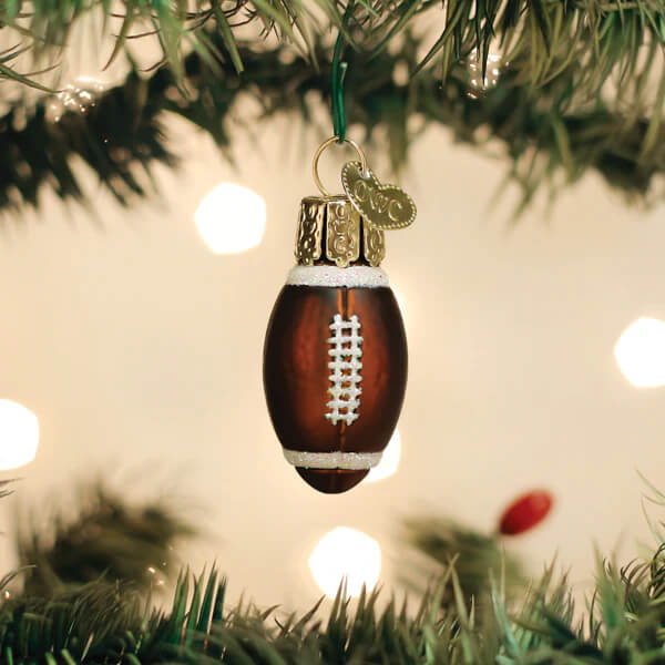 Brown glass mini football ornament with white laces and gold trim hanging from world christmas ornament tree