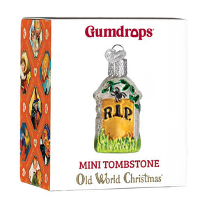 Mini tombstone ornament made of clear glass with a yellow plaque green grass base and black r.i.p. lettering
