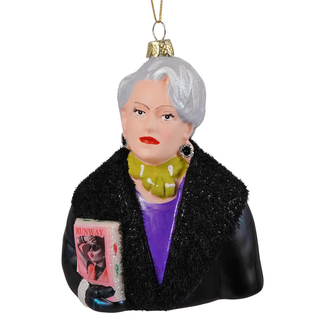 Miranda priestly glass ornament showing a silver-haired woman in a black fur coat holding a pink runway magazine