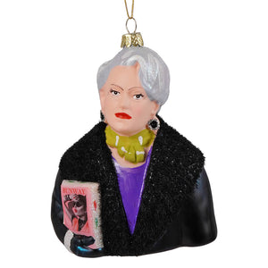 Miranda priestly glass ornament showing a silver-haired woman in a black fur coat holding a pink runway magazine
