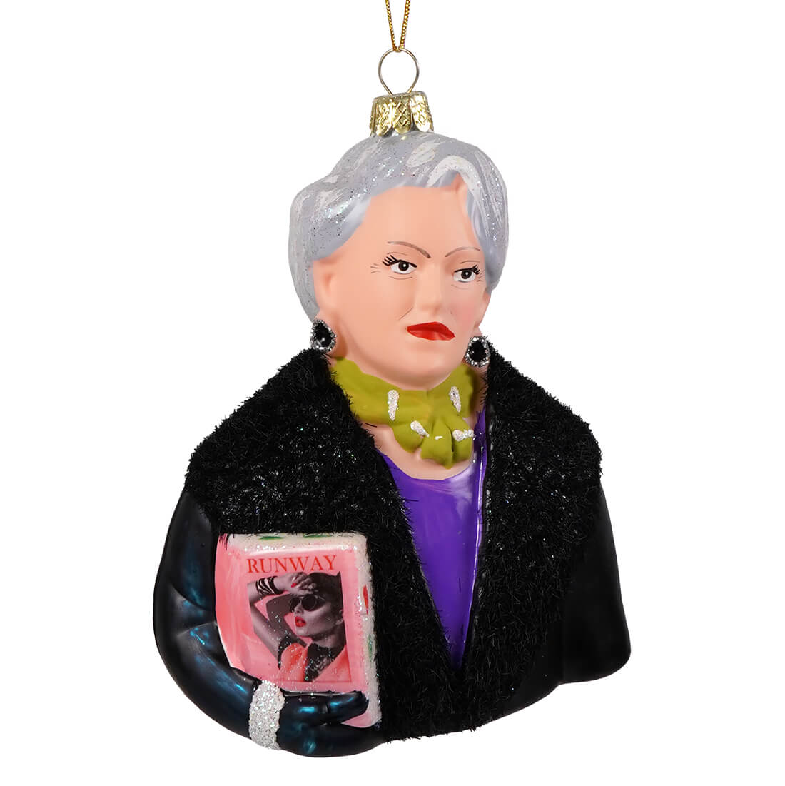 Miranda priestly glass ornament featuring a silver haired woman in black fur coat holding a pink runway magazine