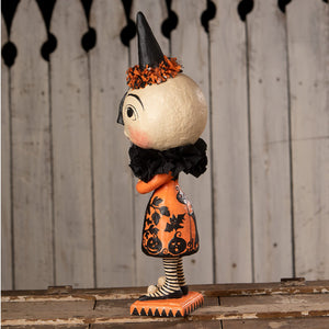 A whimsical miss moon halloween witch figurine with cream head, black hat with orange tinsel, and orange pumpkin dress by bethany lowe