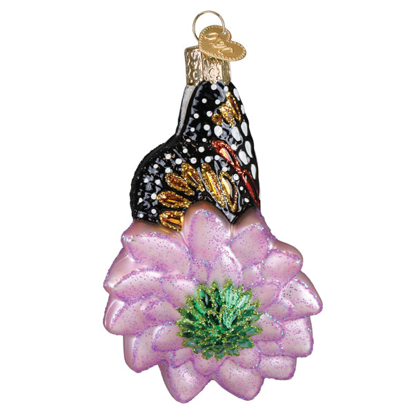 Delicate christmas glass ornament with a black and gold monarch butterfly on a glittery lavender flower center green