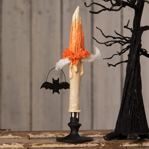 A halloween-themed mr flame candle with an orange flame top white ruffle trim on a black stand by bethany lowe halloween