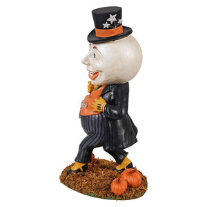 A halloween-themed figurine of harvey moon man wearing a black starry top hat and holding an orange pumpkin bag