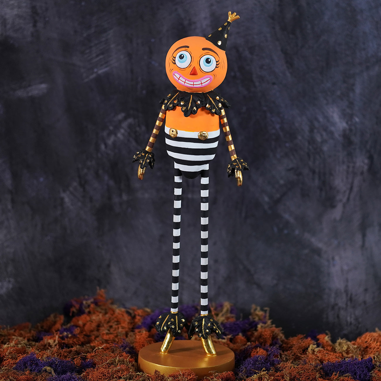 Orange kook pumpkin man figurine with black and white striped body gold accents and party hat for halloween pumpkins gourds display