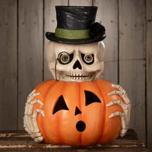 A skeleton decor figure named mr skully wearing a black top hat with a green band holding an orange halloween pumpkin