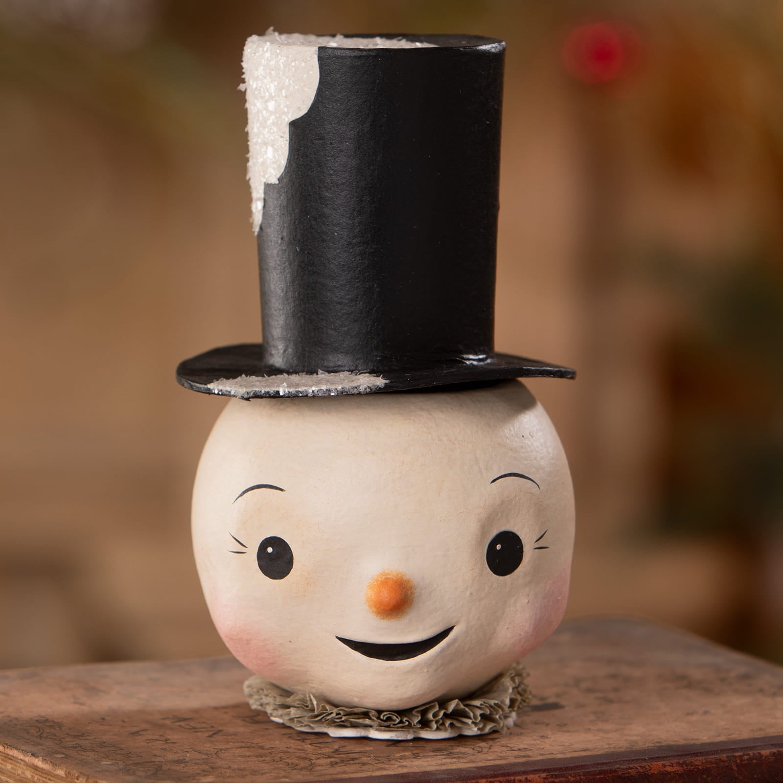 A charming cream-colored jolly bobble snowman container with a black glitter top hat and rosy cheeks for christmas snowman decor
