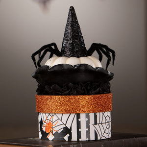 Mrs casperita halloween-themed decorative box with black glitter witch hat and spiders on white and black patterned surface