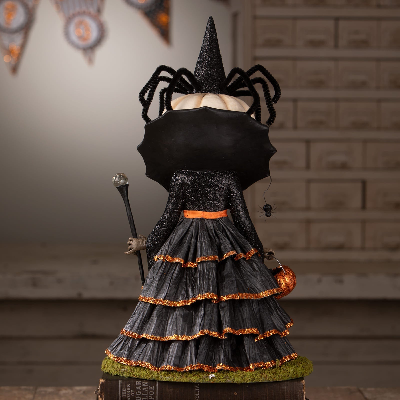 Mrs casperita black witch figurine with glittery hat holding halloween pumpkins and gourds for halloween figural decor