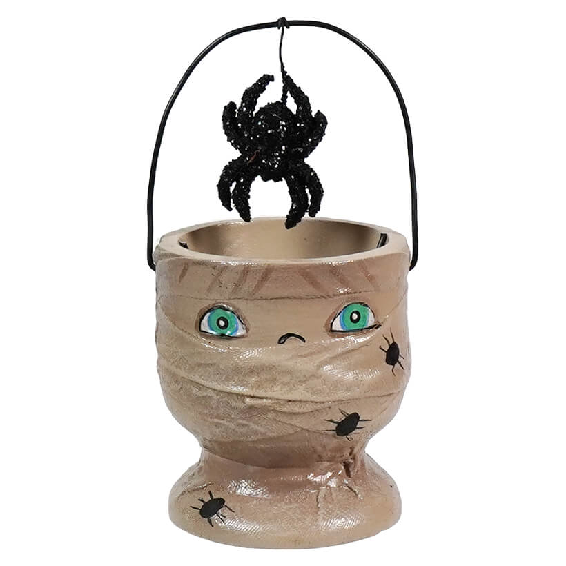 Halloween-themed candy bucket shaped like a mummy’s head with a spider hanging above it.