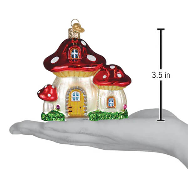 A charming red and white mushroom house ornament made of glass with a yellow door and green grassy base perfect for christmas