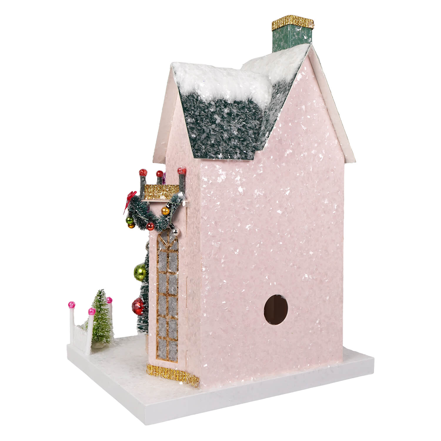 A pink glittery cody foster birdhouse with snow roof and gold trim decorated for christmas village holiday display