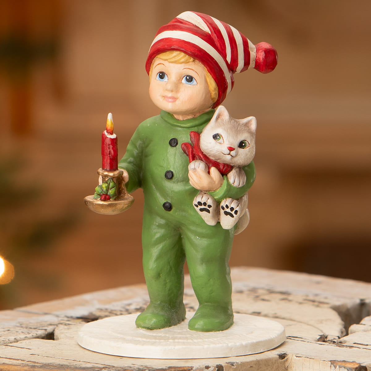 A charming bethany lowe elf christmas ornament holding a lit candle and cradling a gray cat with red scarf