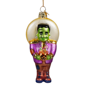 Green glass frankenstein monster ornament in purple jacket holding pumpkin basket with candy swirls for halloween ornaments