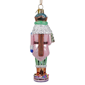 A pink glass nutcracker ornament from kurt adler noble gems™ collection with glittery teal crown and striped pants