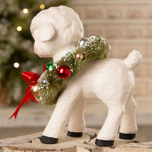 White ceramic noelle lamb with wreath featuring green frosted greenery and red gold silver ornaments by bethany lowe design