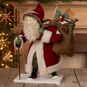 Old st nick santa figure by bethany lowe designs with red and white suit green hat and bag of folk art toys