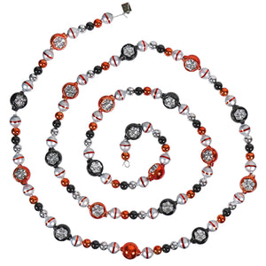 Spiral-shaped necklace or beaded garland made of red, black, and silver decorative beads.