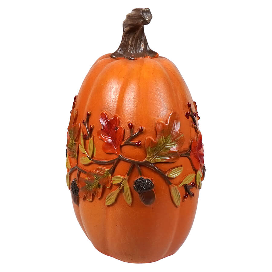 Decorative orange pumpkin with autumn leaf and acorn designs around the middle.