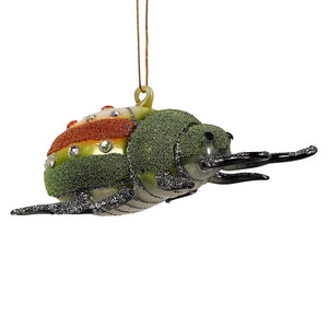A glittery green and orange glass beetle ornament with rhinestone accents from cody foster ornament collection