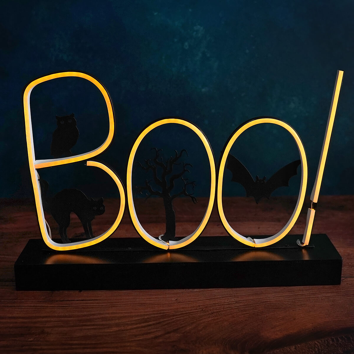 Neon yellow ’Boo!’ sign mounted on a dark base.