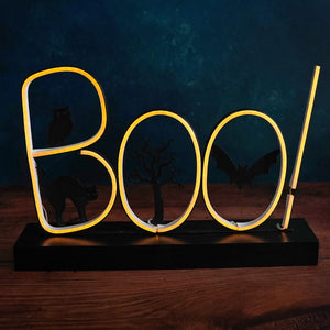 Neon yellow ’Boo!’ sign mounted on a dark base.