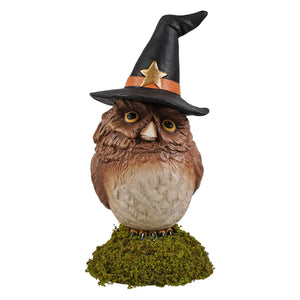 A charming brown owl figurine by bethany lowe design wearing a black halloween witches hat on a mossy base