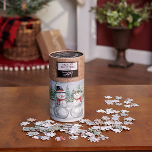 A cylindrical container with a burlap label shows two snowmen in a snowy forest for a painted christmas snow family puzzle