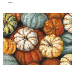 A completed painted fall 1000 piece pumpkin puzzle featuring colorful pumpkin designs in orange white green and teal