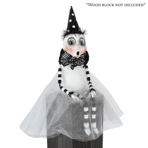 A whimsical black and white party ghost sitter witch figurine with polka dot hat striped bow tie and tulle skirt ghost decor