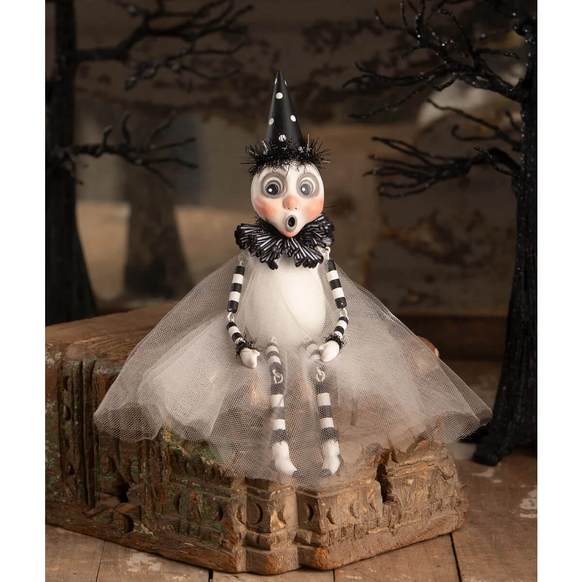 A whimsical white party ghost sitter figurine with black and white striped limbs wearing a polka dot hat and tulle skirt ghost decor