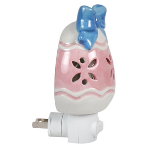 Pastel colored ceramic easter egg night light with white and pink hues and a blue bow perfect for easter lighted decor