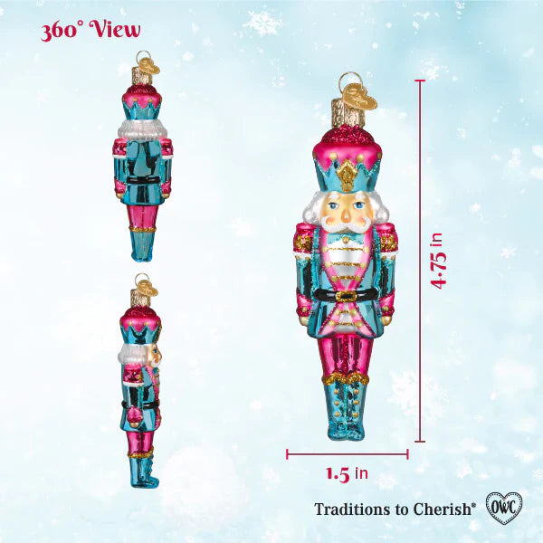 A vibrant hand-blown glass pastel nutcracker ornament in pink teal with gold accents perfect for figural decor or tabletop decor