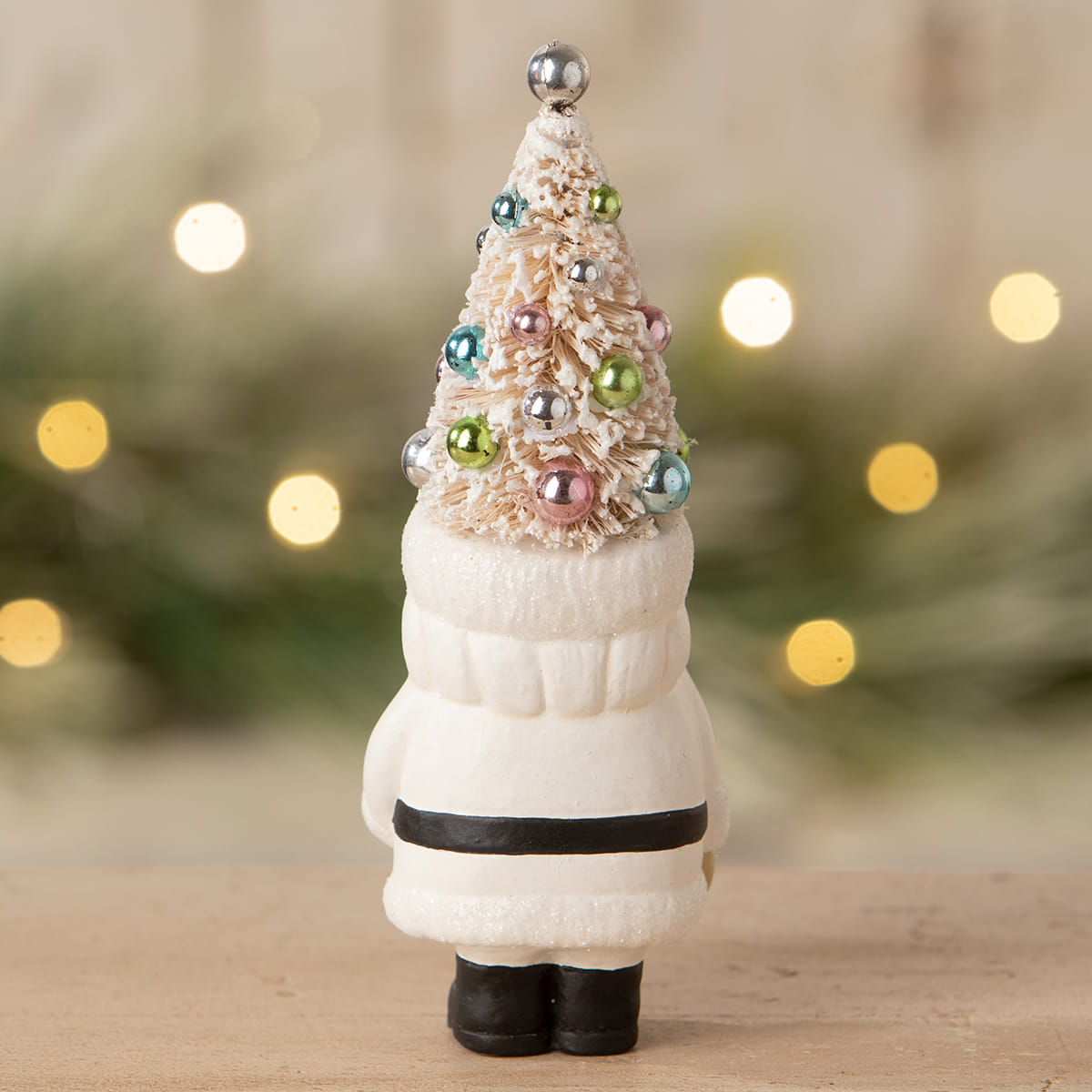A white ceramic pastel tree santa figurine with a frosted tree hat and colorful metallic ornaments by bethany lowe design