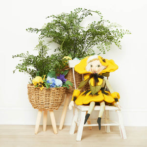 Paulina pansy sunflower-themed doll with black accents and white hair seated on wooden chair by family owned gallerie ii design