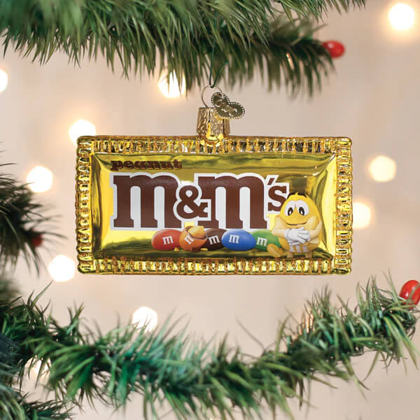 Golden glass peanut m&m’s ornament shaped like a candy bar wrapper with iconic logo and colorful candies