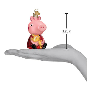 Pink glass peppa pig ornament holding a yellow teddy bear wearing red cape and black shoes for toys and fun miscellaneous ornaments