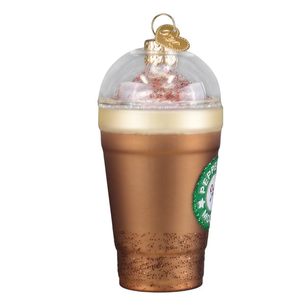 A clear glass peppermint mocha ornament with brown frothy drink white whipped cream red sprinkles tabletop decor