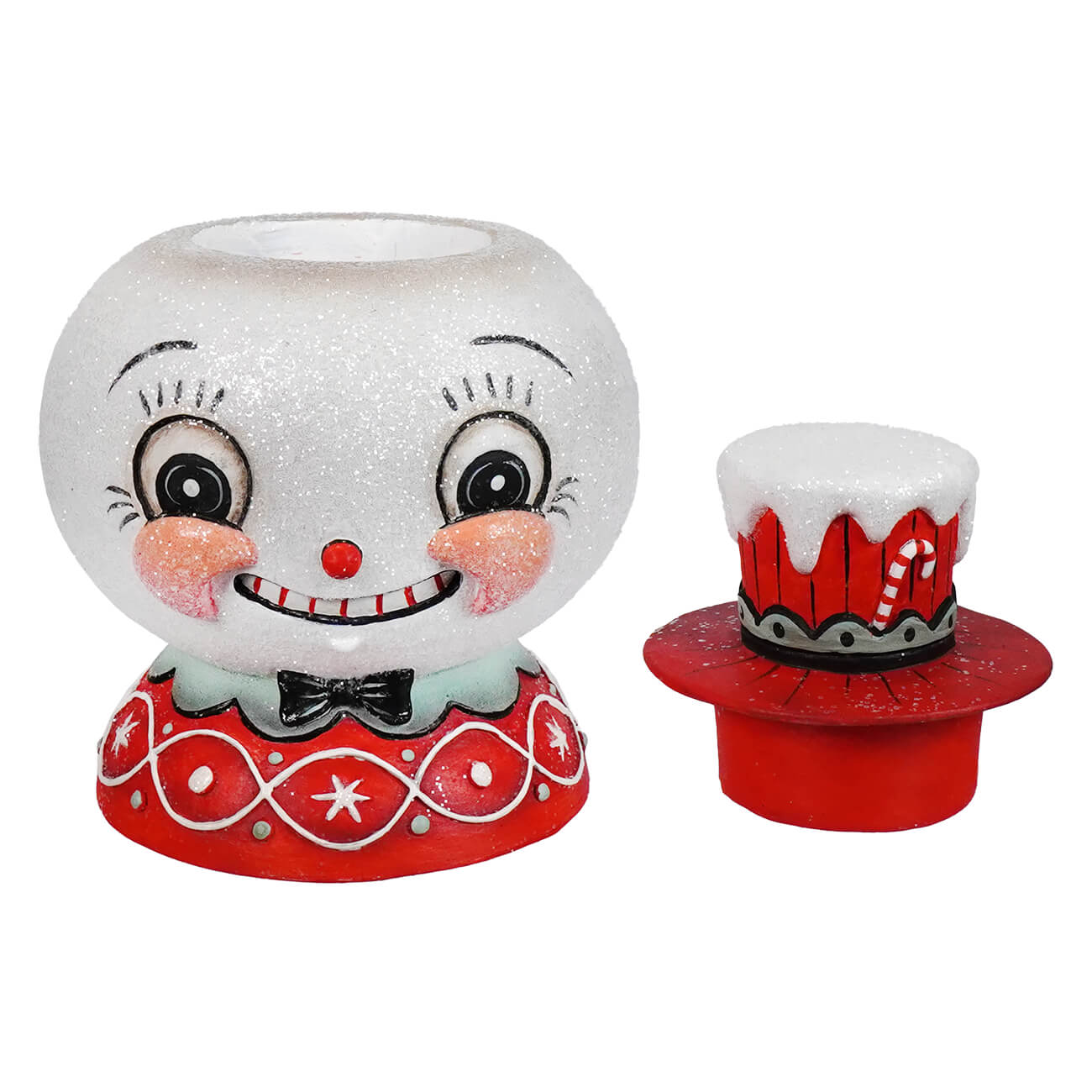 A glittery white snowman candle holder with rosy cheeks and black bow tie on a festive red base peppermint snow beau bethany lowe designs