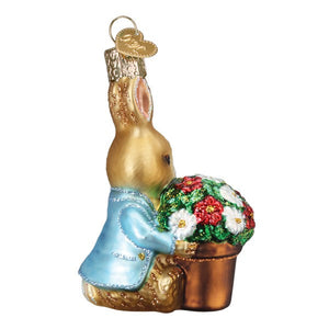 Golden peter rabbit ornament wearing light blue jacket holding copper pot with red and white flowers figural decor inspired by beatrix potters designs