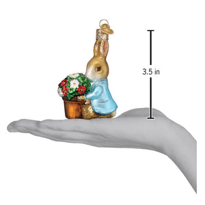 A charming glass peter rabbit ornament by old world christmas featuring a rabbit in a blue coat holding a flower pot for figural decor