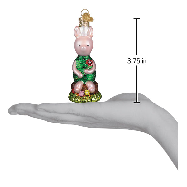 Pink glass piglet ornament wearing a green sequined dress and chef hat sitting on grassy base with tiny flowers for christmas