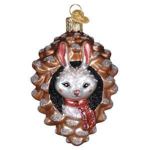 Piney rabbit ornament featuring a white bunny with black wig and red scarf inside a glittery bronze pinecone figural decor