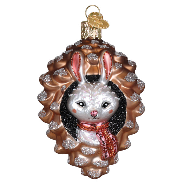 Piney rabbit ornament featuring a white bunny with black wig and red scarf inside a glittery bronze pinecone figural decor