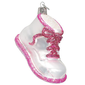 A translucent glass pink baby shoe ornament with glitter accents perfect as cute figural decor for christmas trees