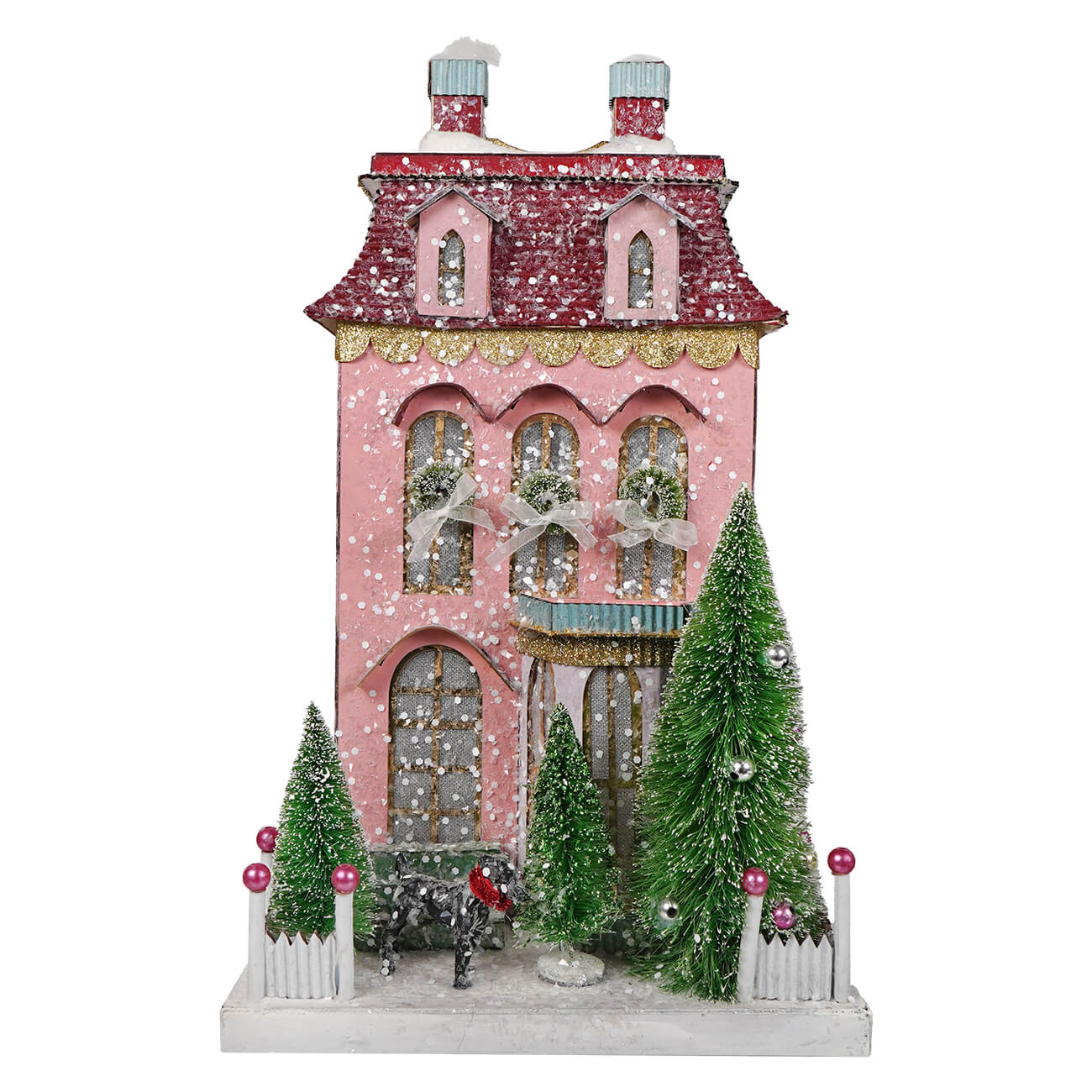 Pink chateau house ornament with pink glitter, red roof, gold trim, and green frosted trees for village decor